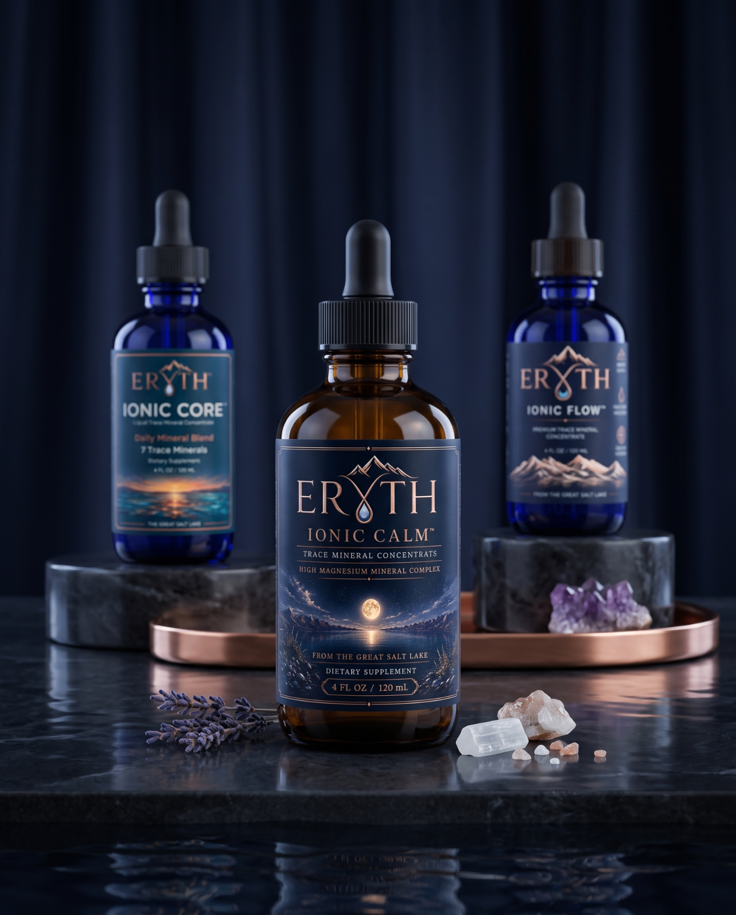 Future Formula System ERYTH liquid trace mineral formula lineup — Ionic Flow, Ionic Core, and Ionic Calm cobalt blue dropper bottles on a travertine stone slab.